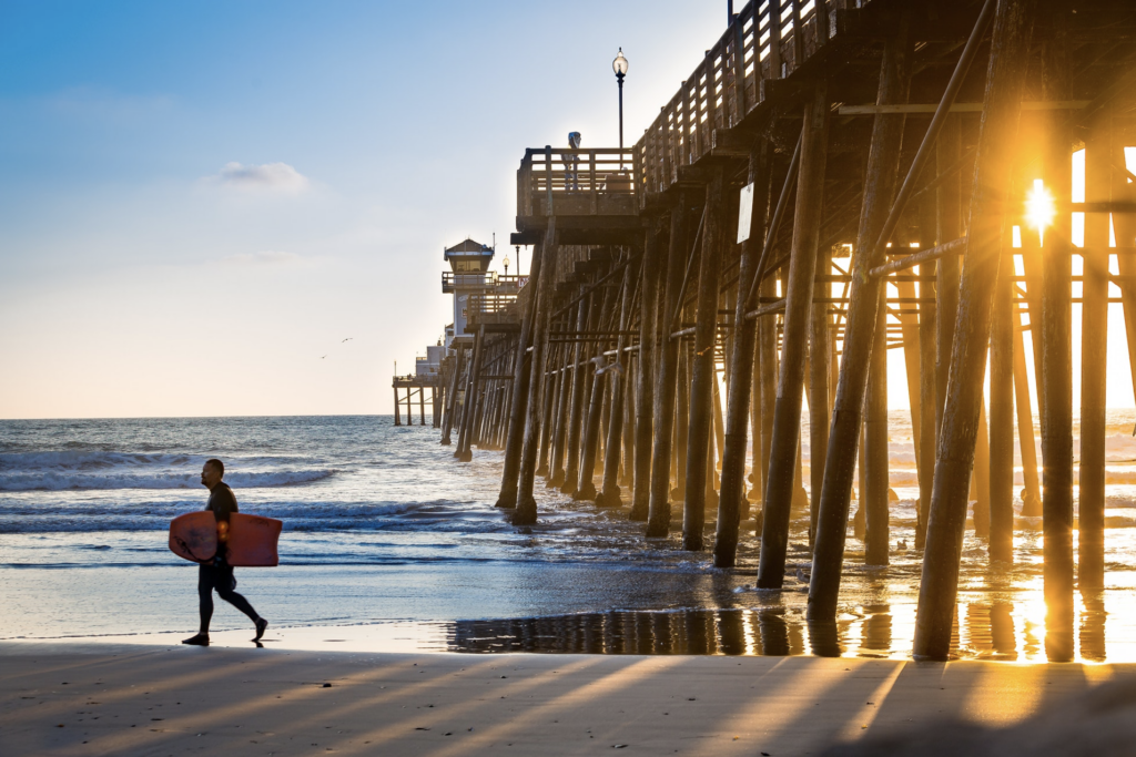 Surfer walking on beach near their Newport Beach home