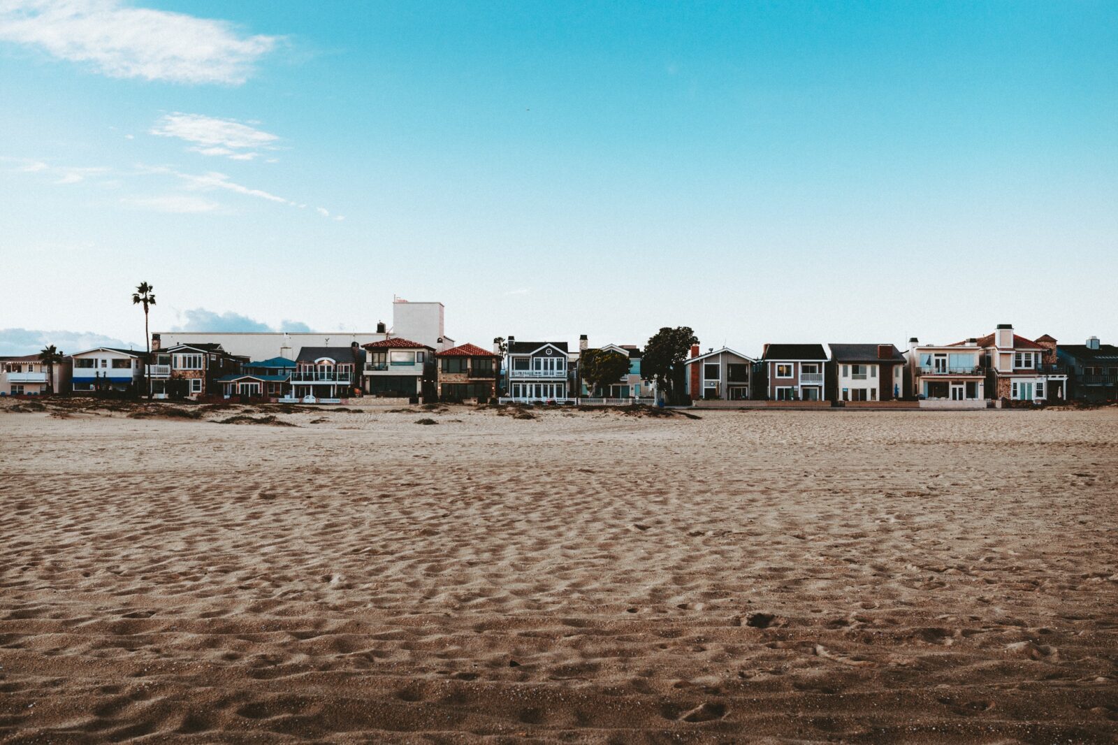 Image of beach houses from the view of someone walking on the shore