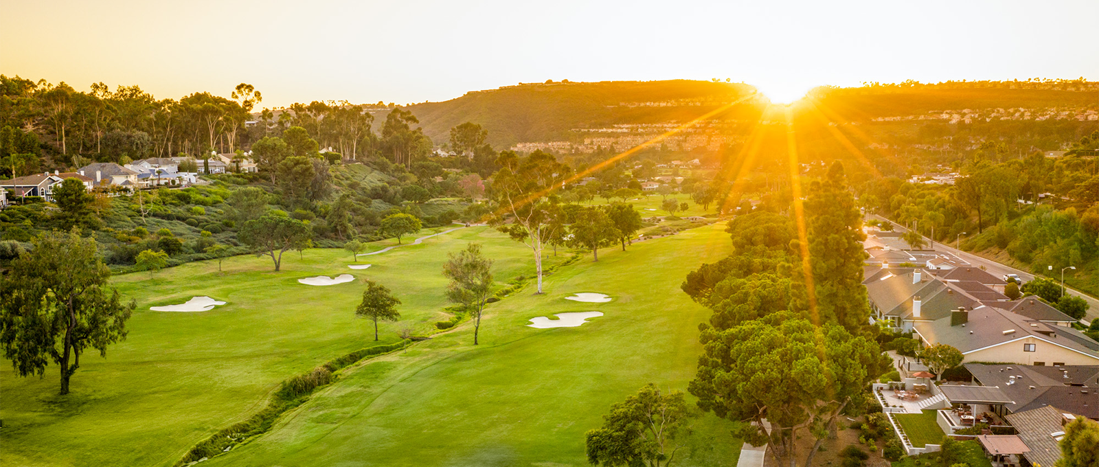 A sunset golden hour lit aerial view of the golfing green
