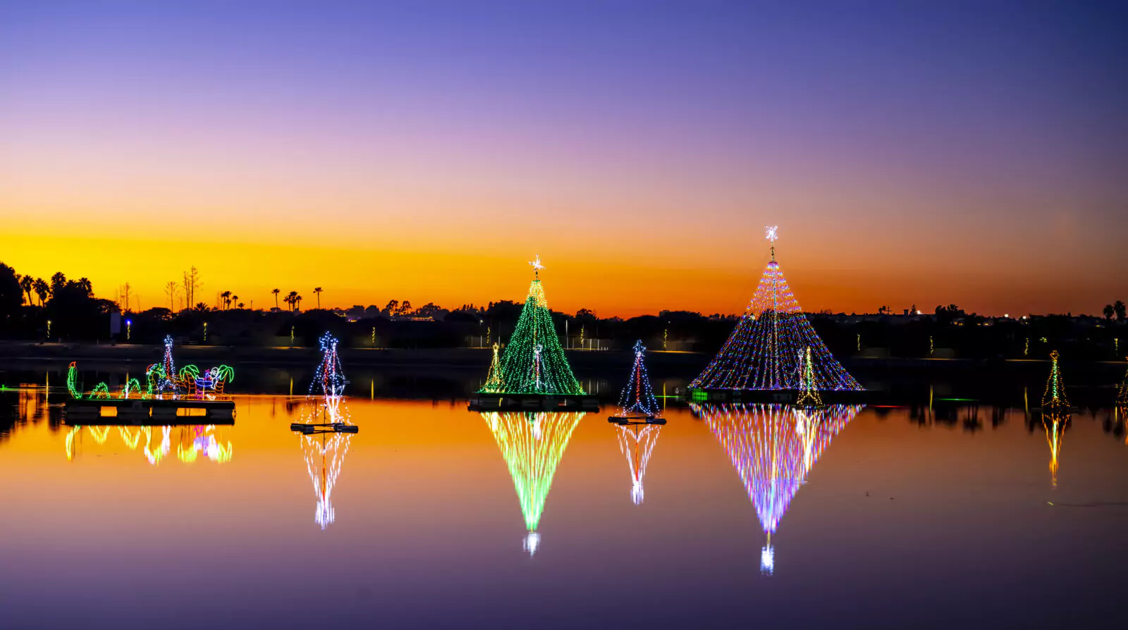 Sunset at Newport Dunes Beach Resort with Orange and Purple Sky and Floating Holiday Light Displays on the Water 