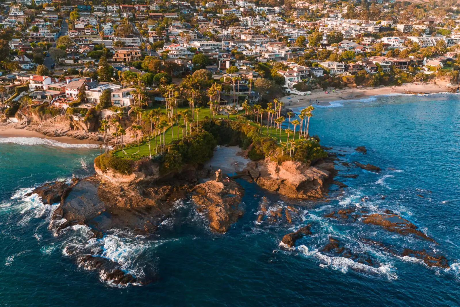 Drone photo of Shaw's Cove in Laguna Beach with luxury homes in the background as sold by Realtor Stavros Group