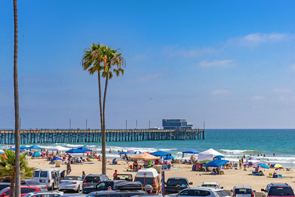 Sunny day at Newport Beach with clear skies and the iconic pier in the background