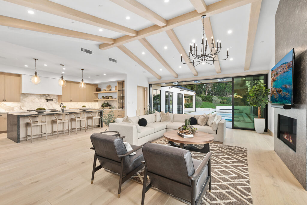 Open concept living area and kitchen with pool access in a luxury coastal Orange County home