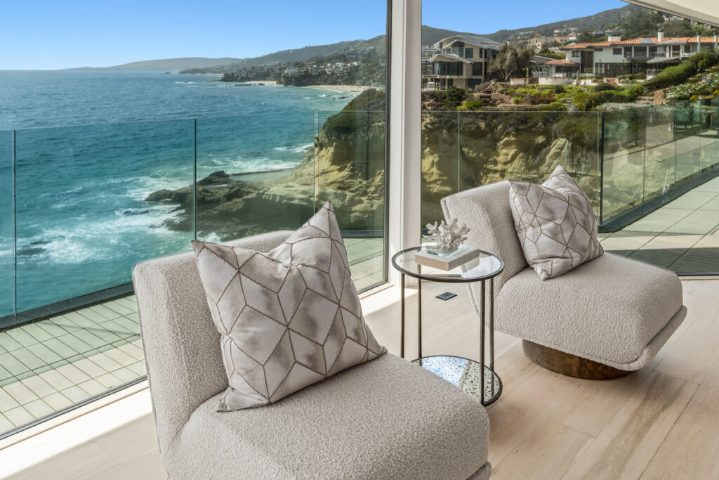 Sitting area with chairs overlooking the ocean and whitewater in a luxury coastal property