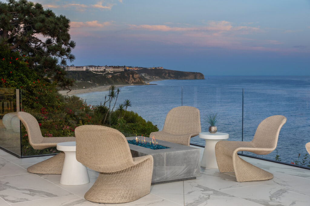 Exterior patio and fire pit of a luxury Monarch Bay home with an ocean view, listed by top real estate agent Andy Stavros