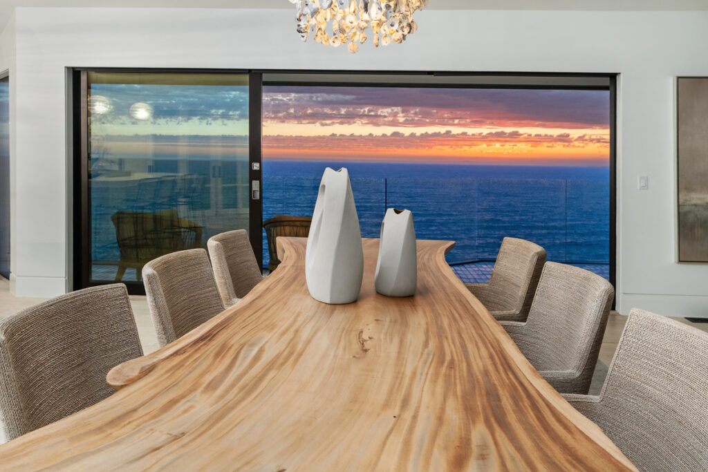 Dining room table looks out to ocean views from this luxury estate in Three Arch Bay represented by top Realtors the Stavros Group