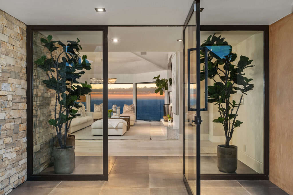 Open front door to Laguna Beach luxury home with views of the ocean beyond