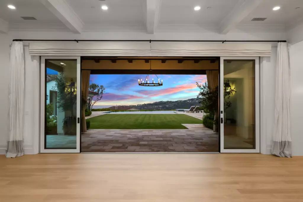 Living room looking out to patio, yard, and ocean views in Newport Beach by the best local realtor agents