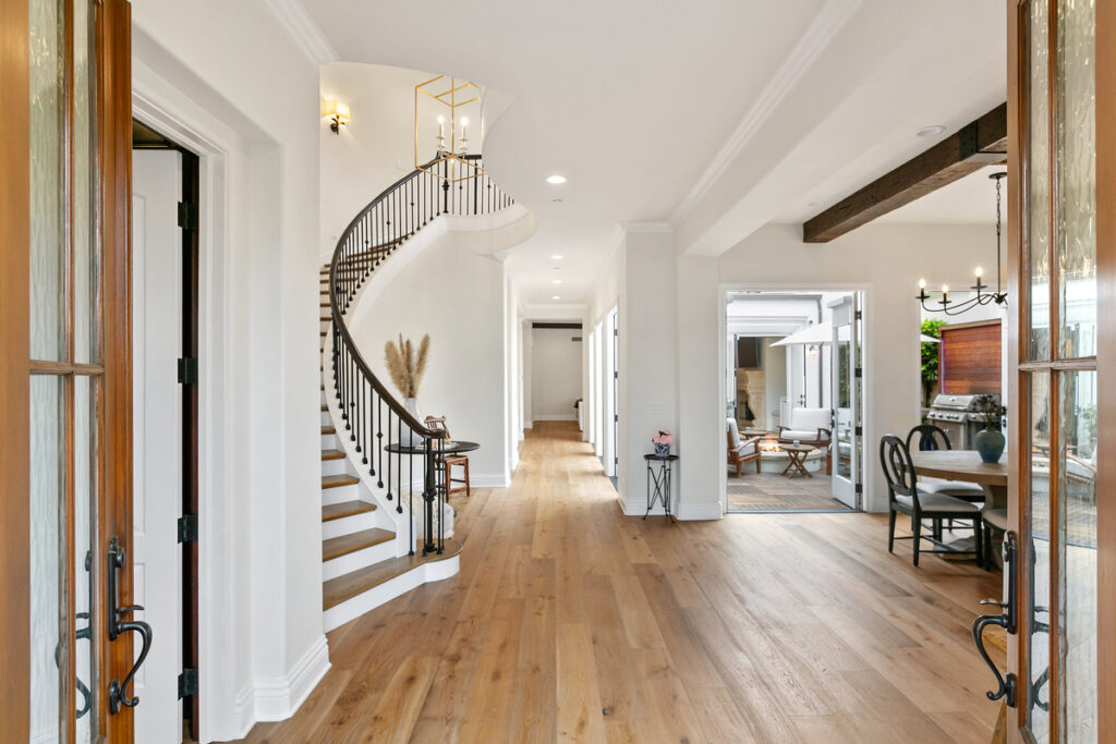 Front door to living room and staircase of luxury home in Newport Beach sold with top local real estate agents