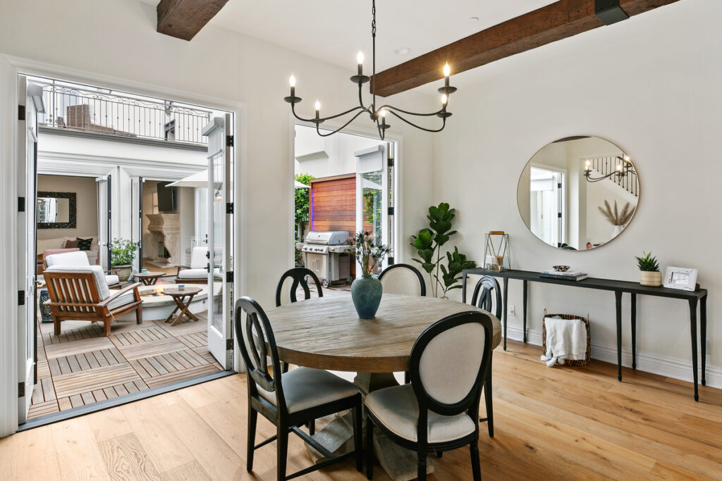 Indoor outdoor dining space and fire pit at luxury home sold in Newport Beach for homeowners