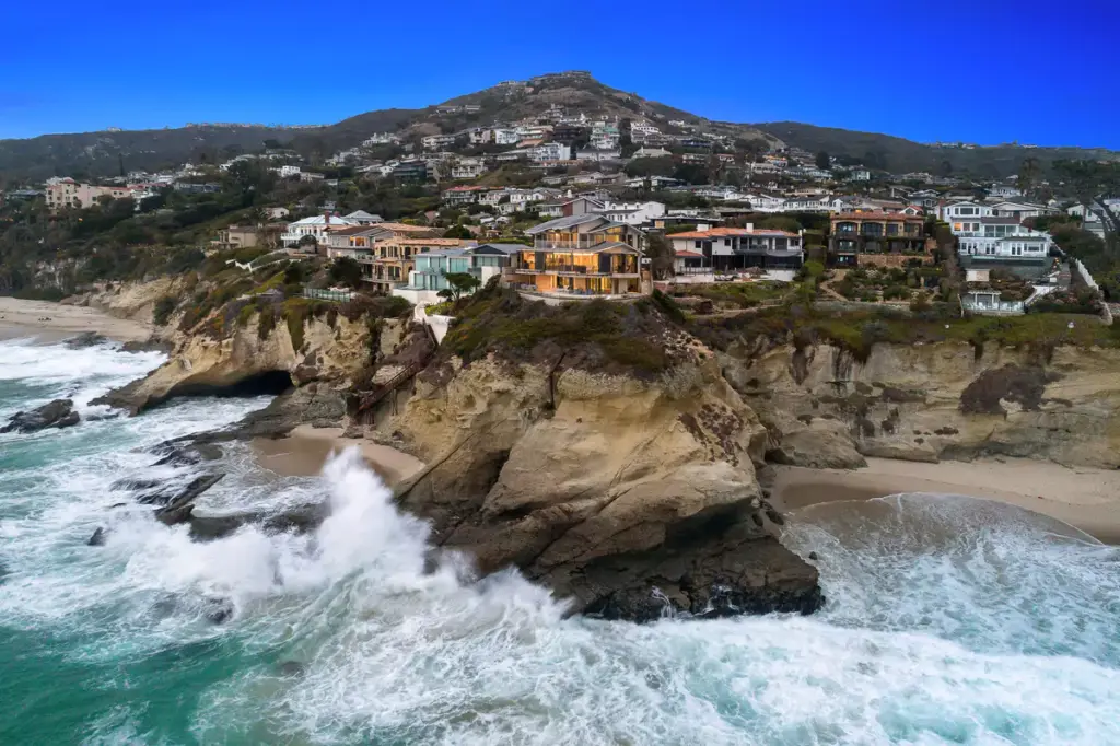 Drone image of Laguna Beach luxury properties on the bluffs above the ocean, representing prime location for real estate home sales
