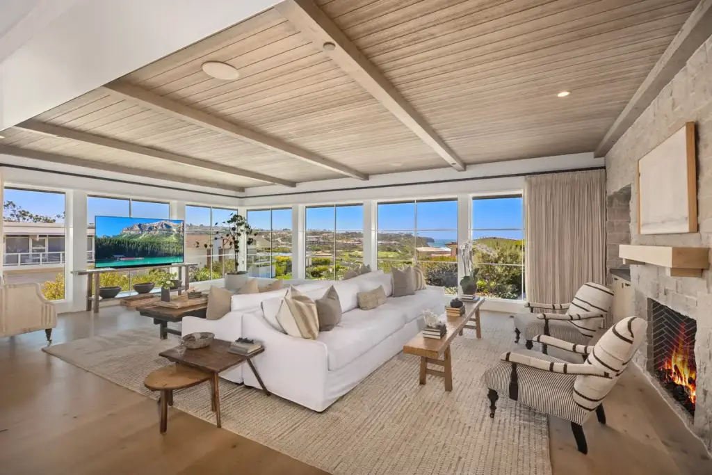 Living room with fireplace and views of the ocean and Monarch Bay golf course, from the best OC luxury realtor agents