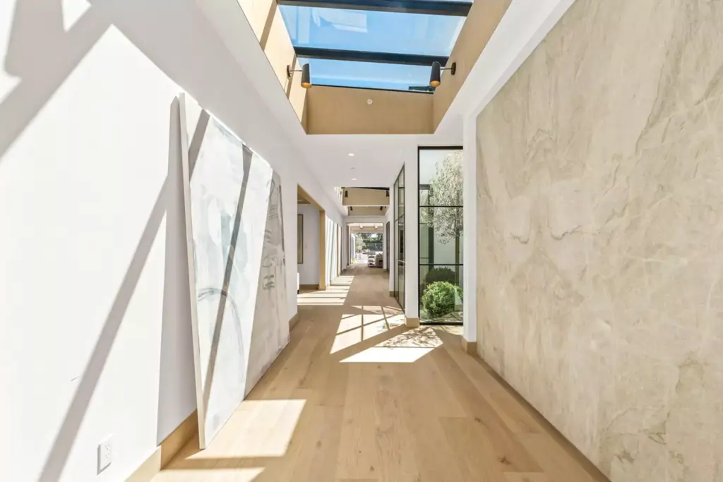 Interior hallway with stone finishes and skylights at a luxury real estate listing by the best Orange County agents for sellers, Andy Stavros Group