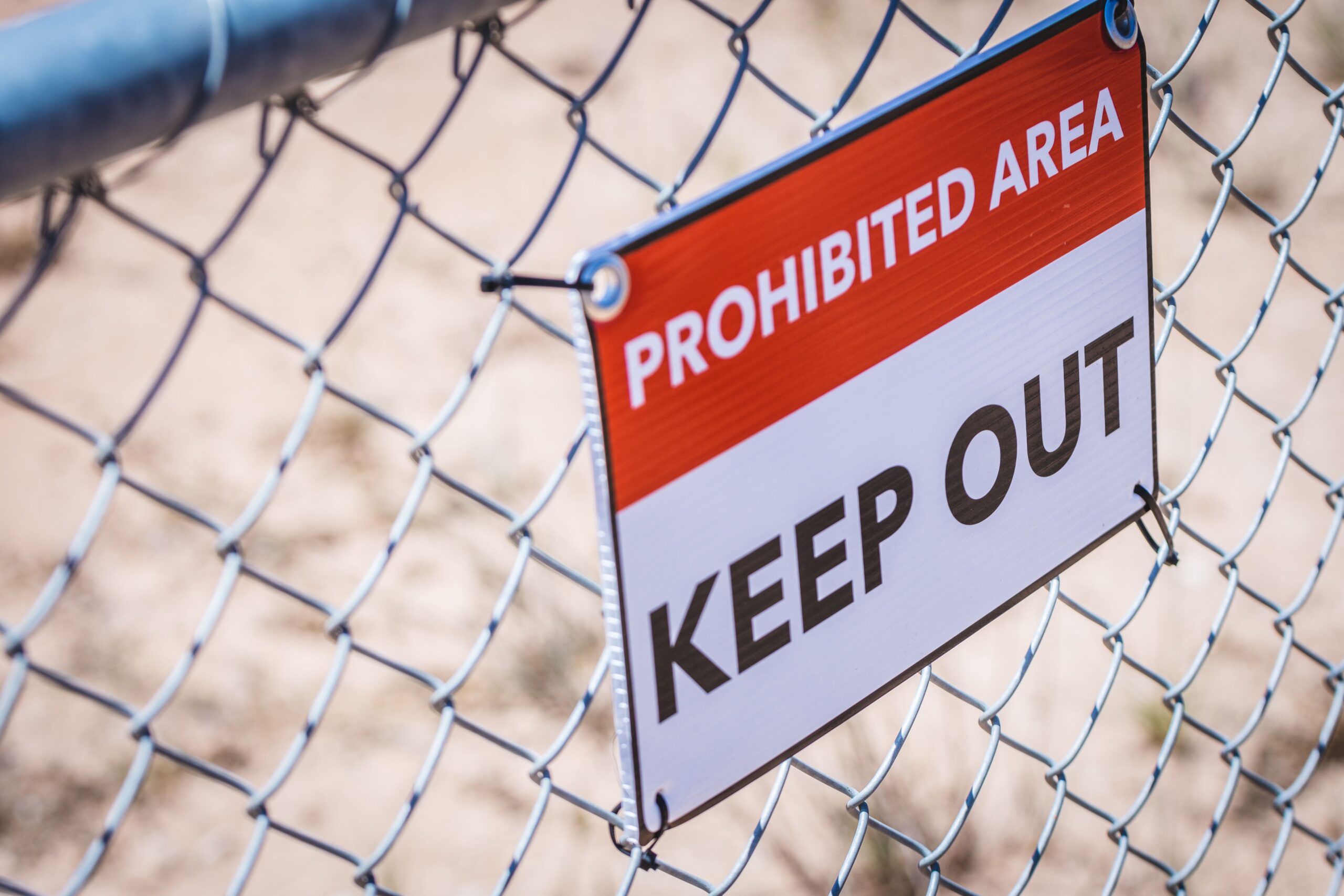 Chain link fence with warning sign of private property keep out, representing a public vs private off-market listing to sell your luxury home in Orange County, CA